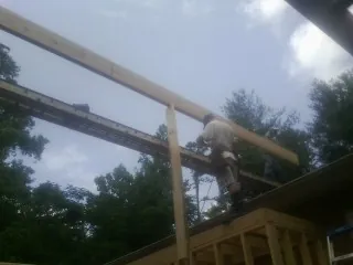 Carpenter setting a ridge beam over a new addition frame — Ice Dam Removal by Roofing Brothers in Orient